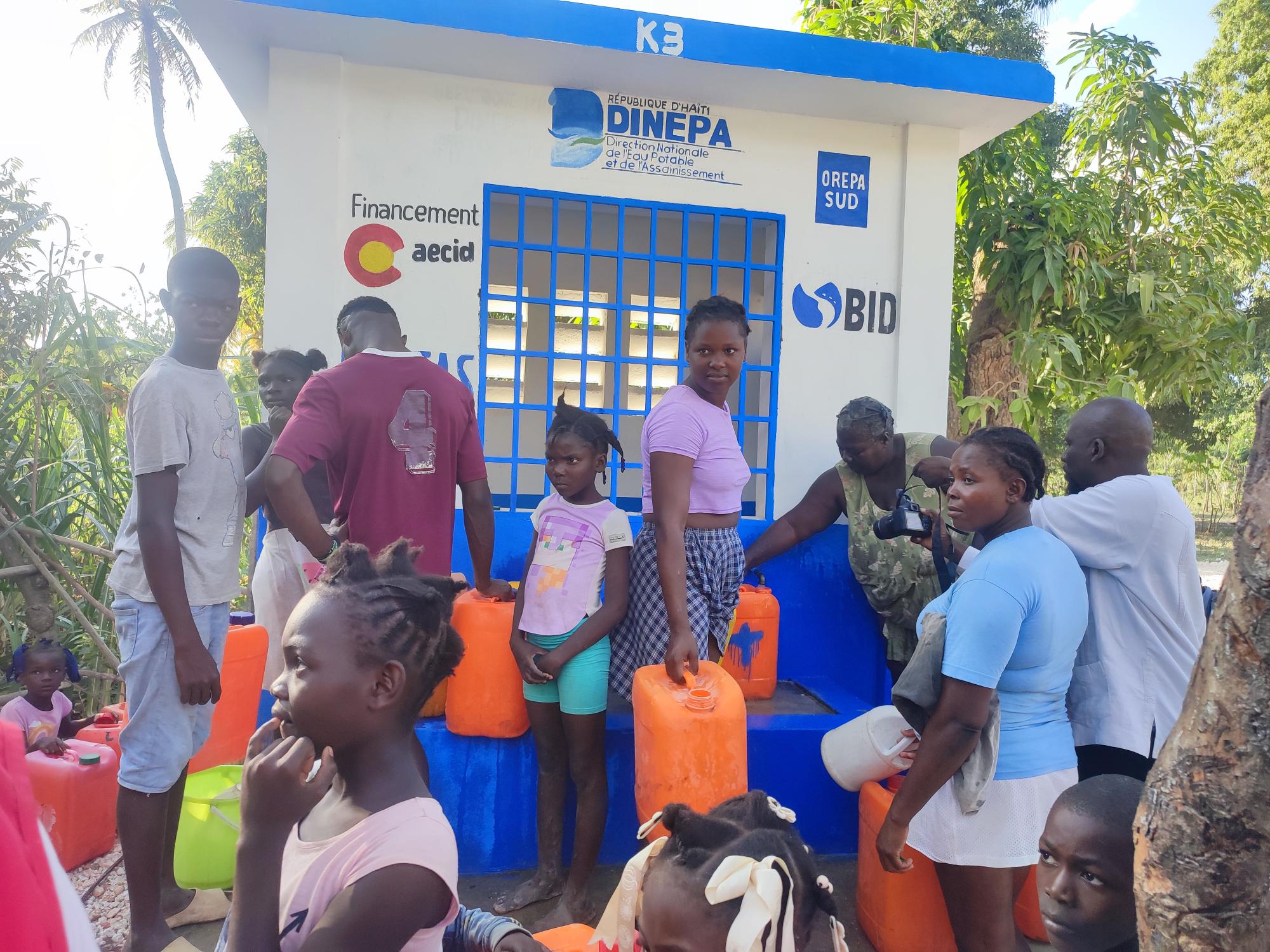 Population de Jacmel devant un point de distribution d'eau.